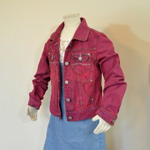 May include: A red denim jacket with silver buttons and a blue denim skirt.