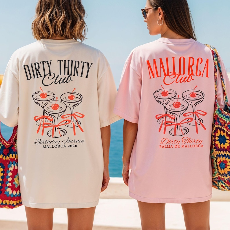 May include: Two oversized t-shirts, one cream and one light pink, featuring back graphics of three martini glasses with red cherries and ribbons. The cream shirt reads "DIRTY THIRTY Club Birthday Journey MALLORCA 2026" and the pink shirt reads "MALLORCA Club Dirty Thirty PALMA DE MALLORCA".