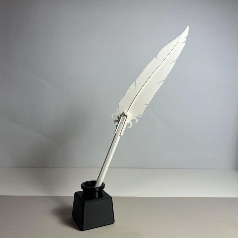 May include: A white feather quill pen in a black inkwell. The quill is made of plastic and has a realistic feather design. The inkwell is a simple, square shape.