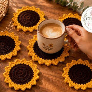 May include: A set of five round, crocheted sunflower coasters featuring dark brown centers and bright yellow petal-shaped borders. One coaster supports a ceramic mug with a floral print. The text CRAFTY BY TIZARI is visible in a circular logo.