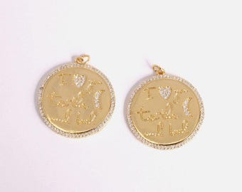 May include: Two gold-colored round pendants with the inscription "I love you to the moon and back". Each pendant has a border of small, clear crystals and a small loop at the top for hanging.