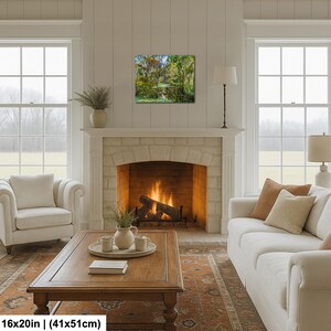a cozy living room with a fireplace, a wooden coffee table, two white sofas, and a large window overlooking a scenic outdoor view.