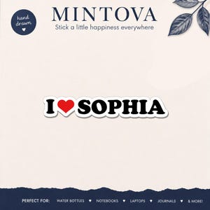 May include: A rectangular sticker featuring the text I, a red heart symbol, and the name SOPHIA in bold black capital letters. The sticker has a white border and is presented against a light background with the brand name MINTOVA at the top.