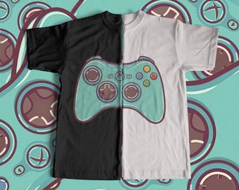 May include: A black and white t-shirt with a teal green video game controller graphic on the front. The controller has a black and white design with a teal green background.