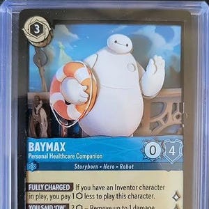 Peut inclure: Une carte à collectionner Disney Lorcana représentant Baymax, un robot blanc tenant une bouée de sauvetage orange et blanche. La carte affiche le texte Baymax, Personal Healthcare Companion, Storyborn, Hero, Robot, Fully Charged et You Said Ow.