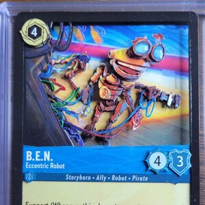 May include: A trading card featuring a robot character named B.E.N. in a protective case. The card has a blue and yellow color scheme with the text "B.E.N. Eccentric Robot". The card is in a black plastic holder.