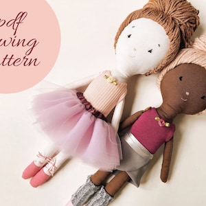May include: Two handmade fabric dolls, one with light skin and brown hair, the other with dark skin and pink hair. Both dolls are wearing dresses and have a flower on their chest. The dolls are sitting on a white surface. The text "pdf sewing pattern" is in a pink circle in the top left corner of the image.