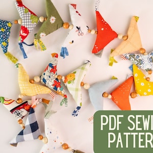 May include: A PDF sewing pattern for making a garland of colorful fabric birds. The birds are strung together with wooden beads. The pattern is available for download.