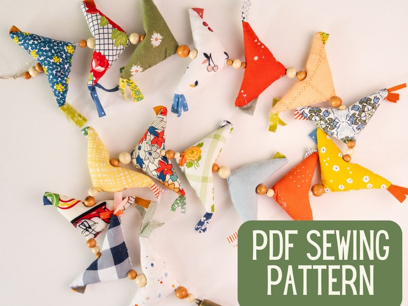 May include: A PDF sewing pattern for making a garland of colorful fabric birds. The birds are strung together with wooden beads. The pattern is available for download.
