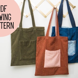 May include: Three tote bags with pockets hanging on a wooden rack. The bags are made of different fabrics: green corduroy, brown corduroy, and blue denim.  The text "PDF SEWING PATTERN" is in the upper left corner of the image.
