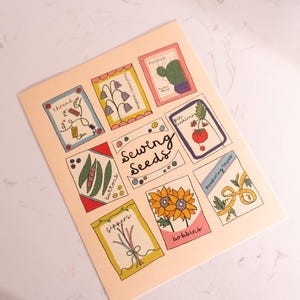May include: A light peach-coloured print featuring illustrated sewing-themed images. The print includes images of thread, buttons, zippers, sunflowers, and other sewing notions. The words "Sewing Seeds" are written in the centre of the print.