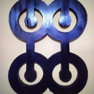 May include: A wooden wall decor piece with a geometric design. The design is made up of four circles with smaller circles inside. The circles are connected by lines. The piece is painted a dark blue color.