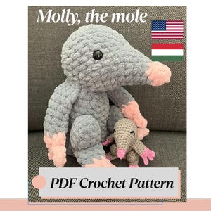 Puede incluir: Un peluche de topo grande de ganchillo gris con detalles rosas en la nariz, los pies y las orejas, acompañado de una versión más pequeña. El texto "Molly, the mole" y "PDF Crochet Pattern" son visibles. Los peluches están sobre una superficie gris.