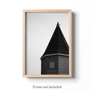 May include: Black and white photograph of a building's tower with a pointed roof. The tower is framed in a light wood frame. The text "Frame not included" is at the bottom of the image.