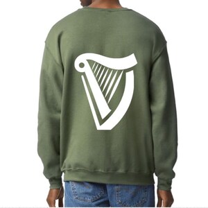 Puede incluir: Una sudadera verde con un logotipo de arpa blanco en la espalda.