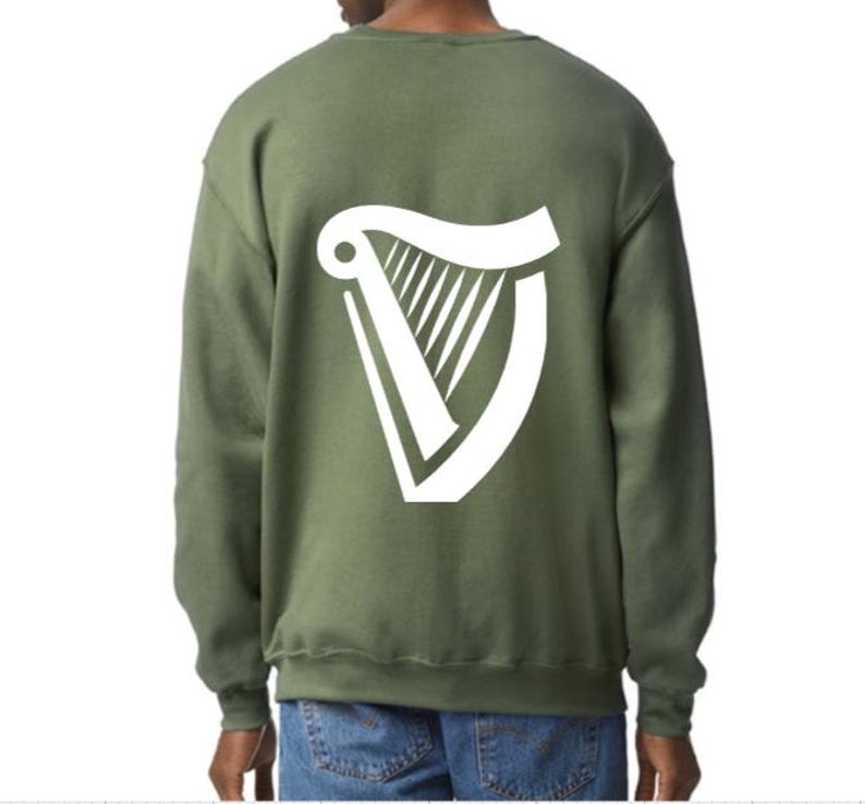 Puede incluir: Una sudadera verde con un logotipo de arpa blanco en la espalda.