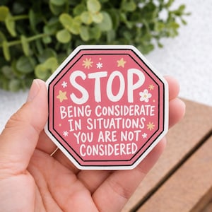 Puede incluir: Una pegatina rosa octogonal con la palabra "STOP" en blanco, encima del texto "SIENDO CONSIDERADO EN SITUACIONES EN LAS QUE NO ERES CONSIDERADO." La pegatina tiene un borde negro y está decorada con pequeñas estrellas y flores.