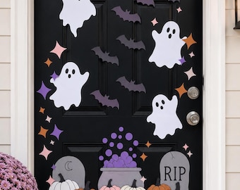 Pode incluir: Uma porta preta decorada com recortes de fantasmas brancos, silhuetas de morcegos roxo-escuros, uma lua crescente creme e estrelas coloridas. Na base, abóboras laranja, rosa, brancas e roxas cercam um caldeirão cinza e uma lápide.
