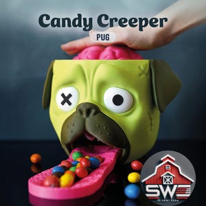 Puede incluir: Un dispensador de caramelos con forma de pug verde y marrón con el texto "Candy Creeper PUG". El dispensador tiene una lengua rosa llena de caramelos de colores y un cerebro rosa en la parte superior. El pug tiene un ojo cosido y un ojo negro.