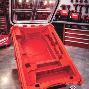 May include: Open red tool case with a clear lid. The interior has molded compartments for tools. The Milwaukee logo is visible in the background.