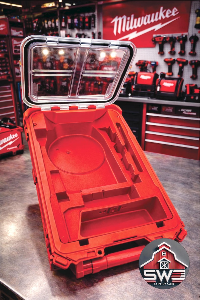 May include: Open red tool case with a clear lid. The interior has molded compartments for tools. The Milwaukee logo is visible in the background.