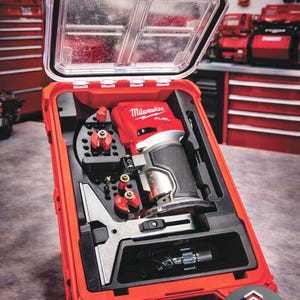 May include: A red Milwaukee FUEL router kit in a red case with a clear lid. The kit includes the router, bits, and accessories. The case has a handle and is designed for easy transport. The Milwaukee logo is visible on the router.