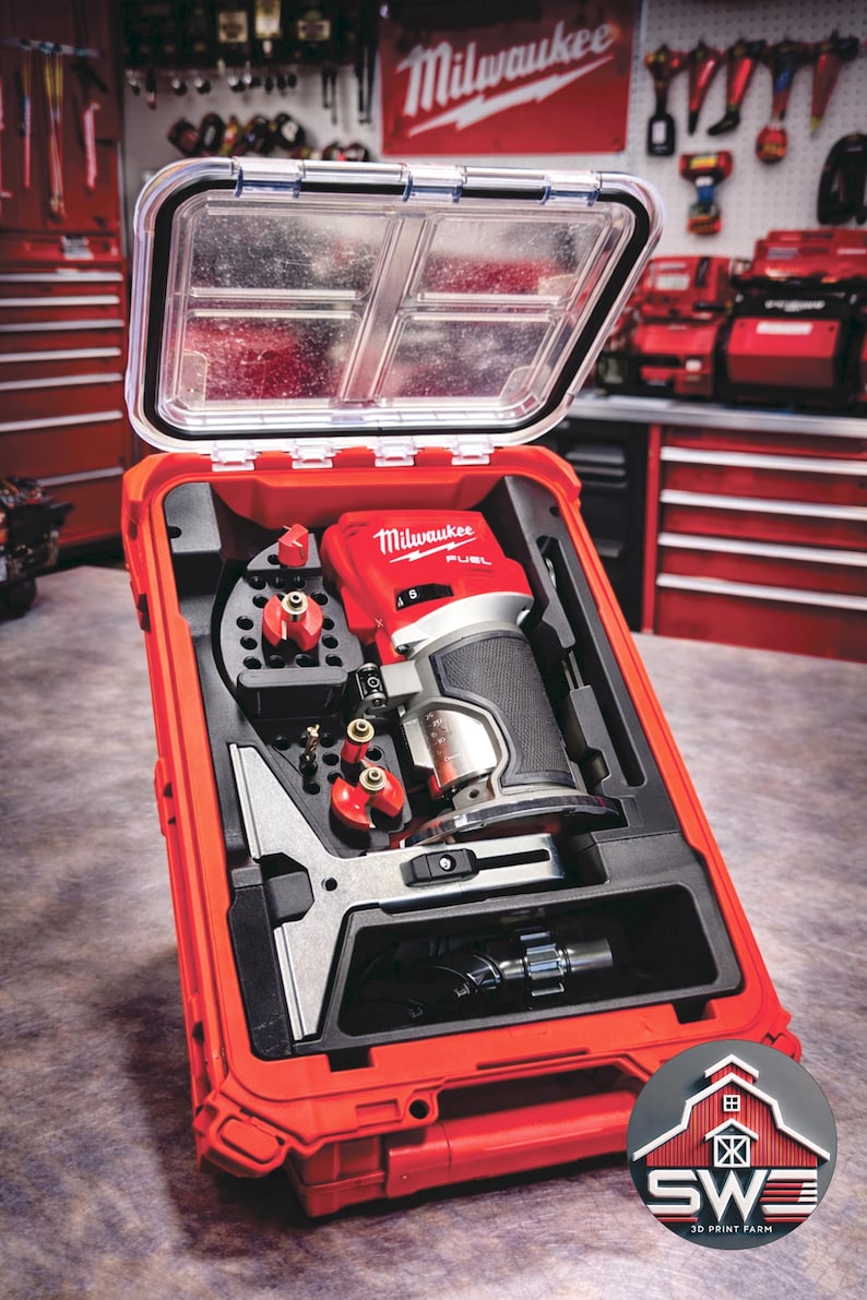 May include: A red Milwaukee FUEL router kit in a red case with a clear lid. The kit includes the router, bits, and accessories. The case has a handle and is designed for easy transport. The Milwaukee logo is visible on the router.