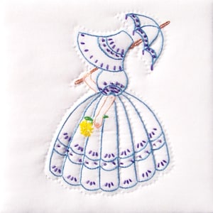 May include: Embroidered white fabric with a blue and purple design of a woman in a dress and hat holding a yellow flower and an umbrella.