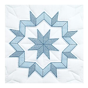 May include: A white quilted fabric square featuring a central eight-pointed star design in shades of blue. The star is surrounded by a geometric border, also in blue, creating a symmetrical pattern. The quilting adds texture and dimension to the textile.