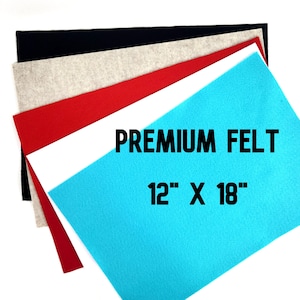 May include: A stack of felt fabric in various colors, including black, beige, red, white, and turquoise. The turquoise felt is the largest piece and has the text "PREMIUM FELT 12" x 18" printed on it.