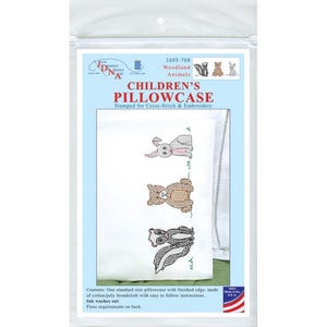 May include: A packaged children's pillowcase kit featuring cross-stitch embroidery. The pillowcase design includes a bunny, bear, and skunk. The package has text that reads "Children's Pillowcase" and "Woodland Animals".