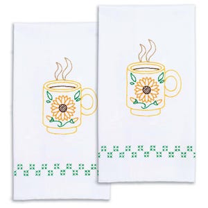 May include: Two white kitchen towels with embroidered designs. Each towel features a yellow coffee mug with a sunflower and steam rising from the top. The bottom of each towel has a green cross-stitch pattern.