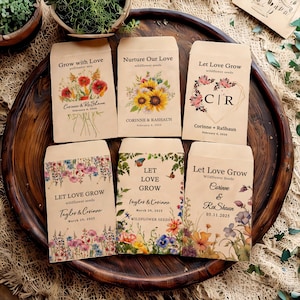 May include: Six brown paper envelopes with floral designs and text. The envelopes are decorated with various flowers, butterflies, and greenery. The text on the envelopes includes the names "Corinne & RaShaun", "Taylor & Corinne", and "Let Love Grow".