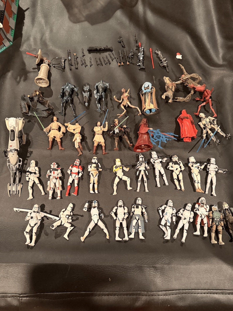 K&ouml;nnte beinhalten: Eine Sammlung von Star Wars-Actionfiguren, darunter verschiedene Charaktere und Sturmtruppen. Die Figuren sind in verschiedenen Posen und weisen detaillierte Designs mit einer Reihe von Farben und Zubeh&ouml;r auf.