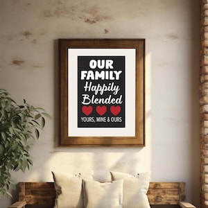 May include: A black and white print with the text "Our Family Happily Blended Yours, Mine & Ours" with three red hearts. The print is framed in a brown frame.