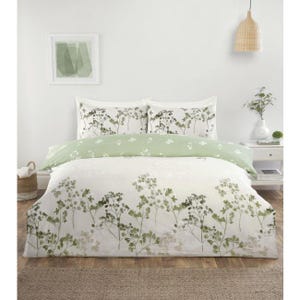 May include: A bedding set featuring a white duvet cover and two matching pillowcases decorated with a green botanical print of delicate stems and leaves. A solid light green folded sheet rests across the top of the duvet cover.