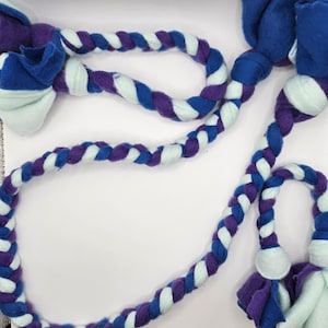 May include: A braided rope dog toy with blue, purple, and white fleece. The rope has two knots at each end, creating a fun and durable chew toy for dogs.
