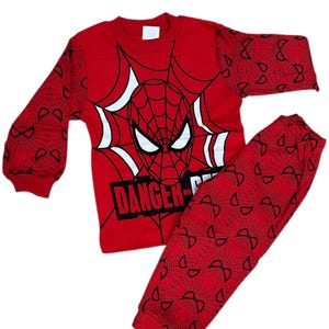 Puede incluir: Pijama rojo y negro de manga larga con un gráfico de Spiderman con el texto "DANGER-D", un diseño de telaraña y un patrón de telaraña negra.