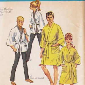 May include: A vintage sewing pattern illustration featuring two styles of robes. One style is a white jacket with a Greek key trim and a tie belt, paired with dark pants. The other is a solid yellow knee-length robe with a tie belt and pockets.