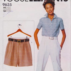 May include: A vintage Vogue pattern cover showing a woman in a blue and white checked shirt and white trousers. The pattern includes shorts with a brown belt and a gold buckle. The pattern number is 9635.