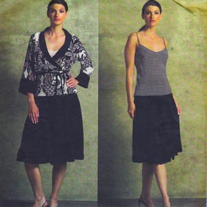 May include: Two-piece ensemble featuring a black skirt and a patterned wrap top with a white underlayer. The wrap top has a black and white paisley design. The second outfit includes a black skirt and a patterned camisole with thin straps.