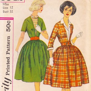 May include: Vintage sewing pattern featuring two illustrated women's dresses. One dress is green with a red belt, the other is orange plaid with a matching belt. The pattern includes sizing information: Miss, Size 12, Bust 32.