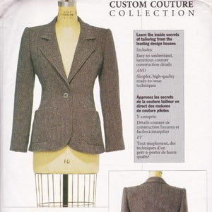 May include: A tailored brown tweed blazer displayed on a dress form. The jacket features a notched lapel, two front pockets, and a single-button closure. The image includes text that reads "CUSTOM COUTURE COLLECTION".