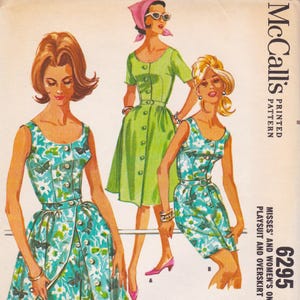 May include: Vintage McCall's sewing pattern featuring illustrations of three dresses. The dresses are in shades of green and turquoise with floral patterns. The pattern includes a playsuit and overskirt design. The pattern number is 6295.