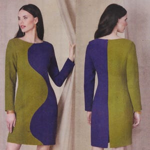 May include: A long-sleeved knee-length dress featuring a color-blocked design in olive green and deep purple. The front displays a curved, wave-like pattern separating the two colors, while the back features a straight vertical color division.