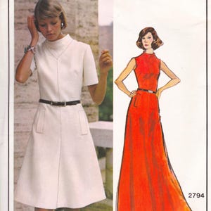 May include: A vintage fashion image featuring a white dress with a high neckline, short sleeves, and a black belt. The dress has a flared skirt and pockets. Next to it is a red dress illustration with a high neckline and a black belt. The number 2794 is in the bottom right corner.