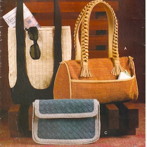 May include: Three woven handbags in various styles. A large tote bag with a black interior and a woven exterior, holding sunglasses and a newspaper. A rectangular handbag with braided handles and tassels. A small, blue woven clutch.