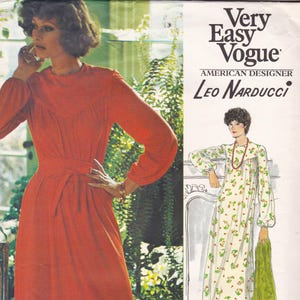 May include: A vintage fashion illustration from Very Easy Vogue featuring a woman in a long-sleeved, rust-colored dress with a belted waist. The image also includes a drawing of a floral-print dress. Text reads "Very Easy Vogue" and "American Designer Leo Narducci."