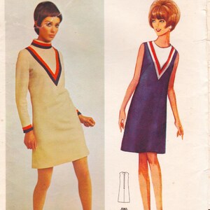 May include: A fashion illustration shows two vintage dresses. One is cream-coloured with long sleeves and a V-neck trimmed in red and navy. The other is sleeveless, navy blue with a white and red V-neck.