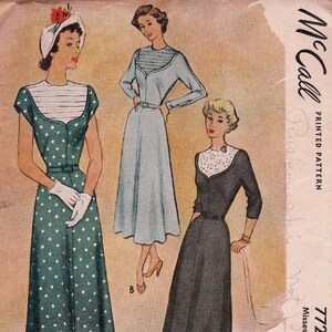 May include: A vintage McCall printed pattern envelope 772 featuring illustrations of three dresses. One is a green polka dot dress with a white striped bodice, one is a light blue dress with a striped bodice, and one is a dark dress with a white lace bodice.